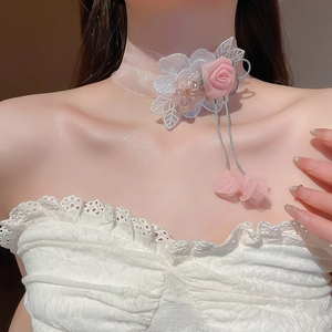 Detail shot of a pink ribbon choker with rose flower and lace embroidery for women