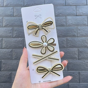 Detail of 4-piece candy color hair clip set featuring pearl bows and flower designs