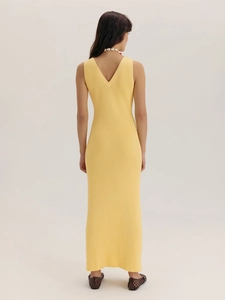 Vue arrière d'une élégante robe longue en maille jaune avec col en V profond et sans manches
