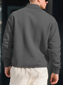 Detailed back view of men's polo shirt showing textured geometric diamond knit fabric