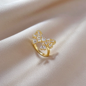 Luxurious gold butterfly zircon ring with sparkling baguette crystals on champagne silk