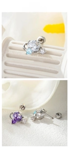 Détail macro de boucles d'oreilles étoile et cœur avec zircons colorés à vis