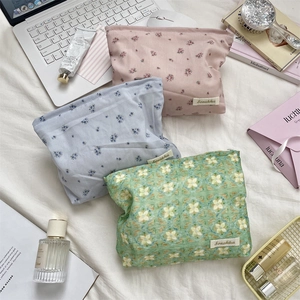 Three floral cotton cosmetic bags on a desk with laptop and lifestyle props