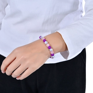 Dettaglio del bracciale elastico con perle viola e rosa per alleviare l'ansia sul polso