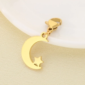Detailed close-up of golden moon and star pendant with lobster clasp on ceramic surface