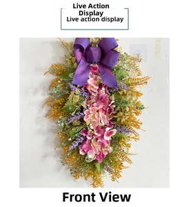 Detail view of pink hydrangea wall decor with purple silk bow and lush green fern leaves
