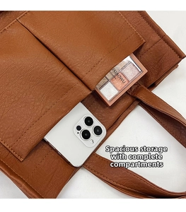 Detail of brown faux leather tote bag with two front pockets for phone and makeup storage
