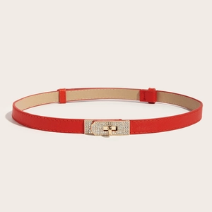 Close-up of thin red leather belt featuring a gold rhinestone-encrusted clasp