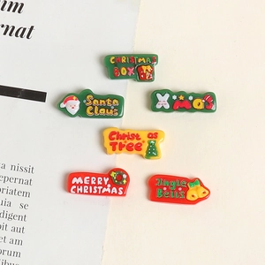 Macro view of six colorful resin Christmas themed charms including Santa and trees