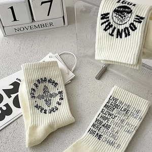 Three pairs of cream-colored rib-knit cotton socks for men in a flat-lay stylish set