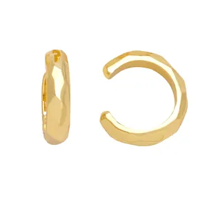 Detailed view of C-shaped gold ear cuff with irregular faceted geometric surface