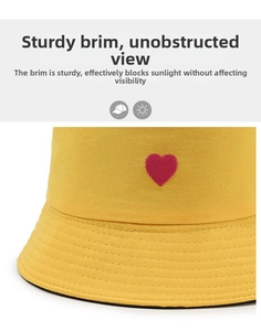 Detailed view of yellow cotton sun hat with embroidered red heart and durable brim
