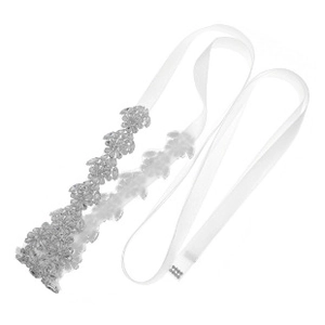 Détail d'une ceinture de mariée avec motifs floraux en strass et ruban de soie blanc pur