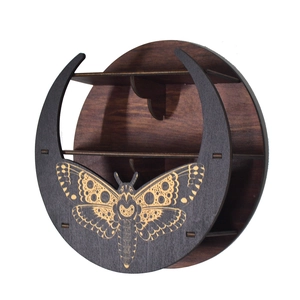 Macro shot of dark wood wall shelf with moth engraving and celestial crescent moon design