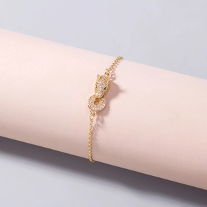 Elegant gold leopard head bracelet with sparkling white zircons and green gem eyes