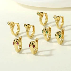 Detailed view of snake hoop earrings with green, red, and black gemstone eyes