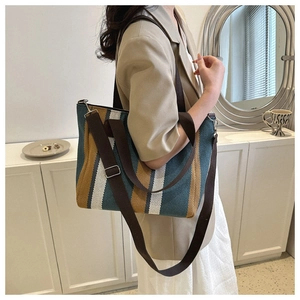 Fashionable vertical striped canvas tote bag shown with shoulder strap in modern room