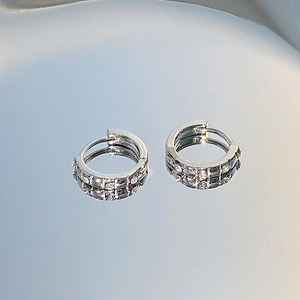 Macro shot of silver huggie hoop earrings featuring micro-pave white zircon stones