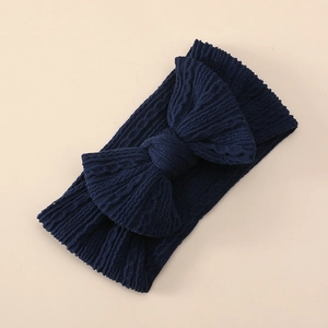 Close-up of navy blue ribbed knit texture and large bow detail on baby headband