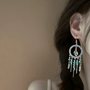 Detail shot of boho turquoise beaded tassel earrings, vintage ethnic style for women's vacation.