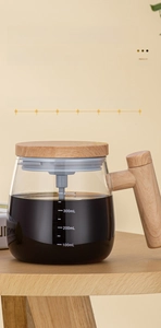 Detail view of a glass coffee pot with ergonomic wooden handle and clear volume markings