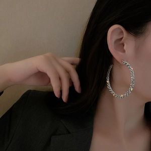 Elegant large silver geometric hoop earrings with sparkling clear crystals on model