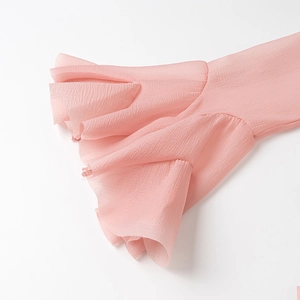 Detailed close-up of pink flared bell sleeves with delicate chiffon ruffle texture