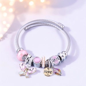 Macro view of butterfly pendant, pink enamel beads and LOVE engraving on steel bracelet