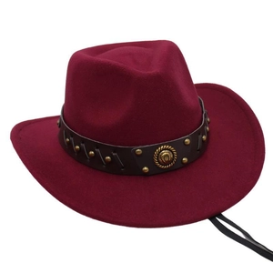 Close-up of burgundy felt western cowboy hat with studded leather band and metal badge