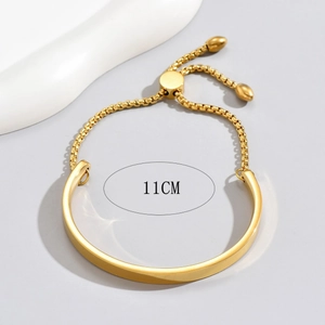 Minimalist adjustable gold stainless steel bangle featuring a sliding bead and drop charms