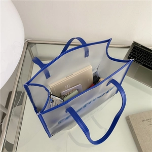 Modern transparent blue tote bag with large capacity for daily essentials on office desk