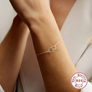 Minimalist S925 sterling silver double interlocking ring bracelet on female wrist