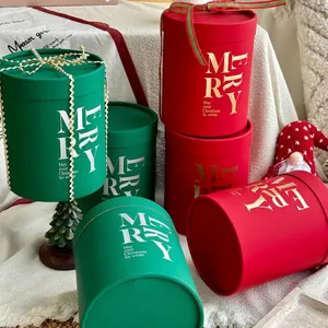 Christmas round gift boxes in red and green with festive Merry text and gold ribbons