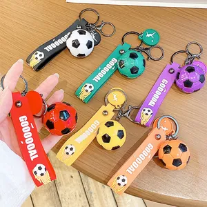 Set di portachiavi calcio colorati con cinturini GOOOOOAL su tavolo di legno
