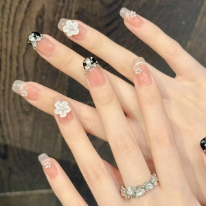 French bow press-on nails with 3D floral relief and pearl accents in nude tones