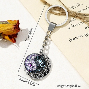 Close-up of rotating Tai Chi pendant keychain with butterfly and floral patterns
