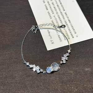 S999 sterling silver bracelet with zircon bow and blue gourd charm on wood background