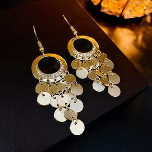 Detailed view of golden leaf sequin tassel earrings with sparkling zircon accents