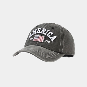 Close-up of vintage washed grey baseball cap with America EST 1776 embroidery and flag patch