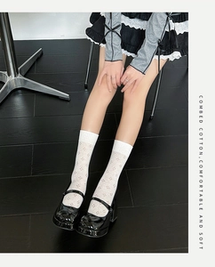 Detail of white hollow patterned mesh crew socks made of soft combed cotton fabric