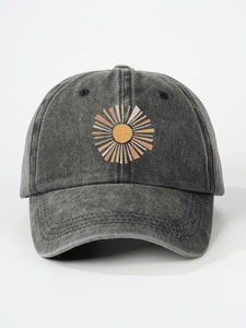 Detail of embroidered abstract sun graphic on washed charcoal grey cotton baseball cap