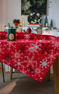 Detail of red Christmas tablecloth with white snowflake patterns and stitched edges