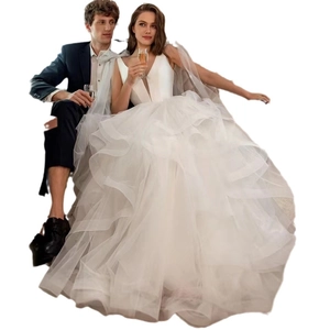 Elegant white tulle layered wedding dress with deep V-neck and ruffled floor-length skirt