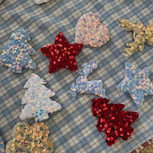 Macro detail of assorted sequin Christmas fabric patches in star and heart shapes