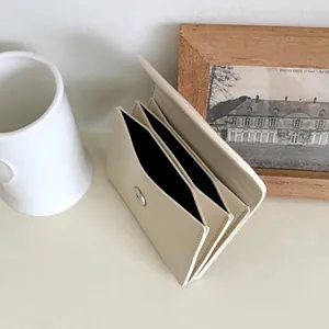 Minimalist off-white accordion card holder with magnetic snap and multi-layer slots