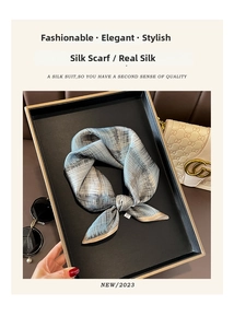 Detail of silk scarf with grey-blue and gold grid patterns in an elegant setting