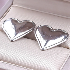 Detailed view of polished heart shaped 304 stainless steel earrings in a jewelry box