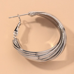 Macro detail of silver layered interlocking hoop earrings with high-polish mirror finish