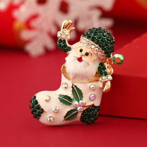 Vintage Santa Claus brooch with green rhinestones and colorful enamel on a golden base