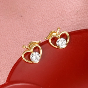 Macro shot of 24k gold-plated apple earrings featuring sparkling cubic zirconia stones